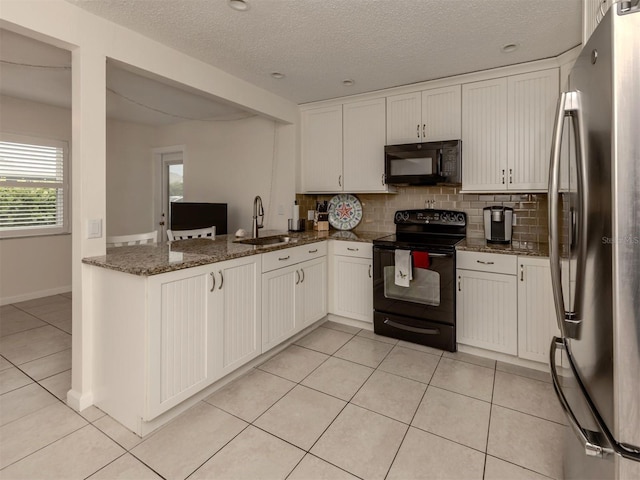 kitchen with white cabinetry, dark stone countertops, and black appliances