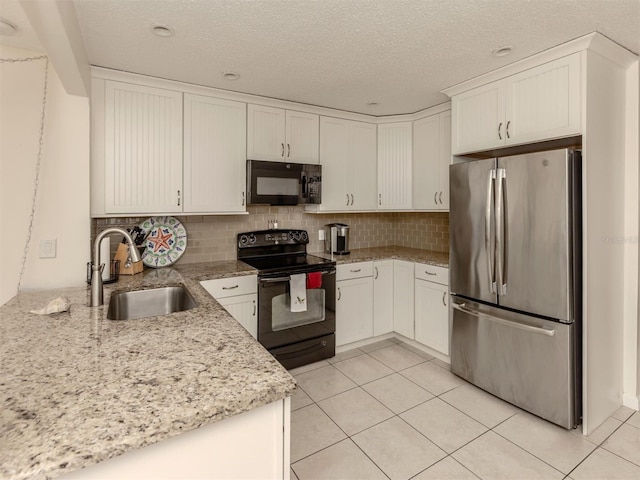 kitchen featuring black appliances, sink, light tile patterned flooring, light stone counters, and white cabinetry