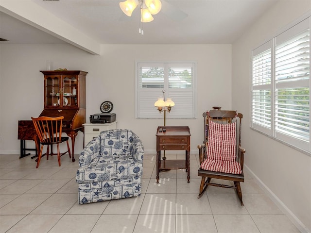 living area featuring ceiling fan, light tile patterned flooring, and beam ceiling