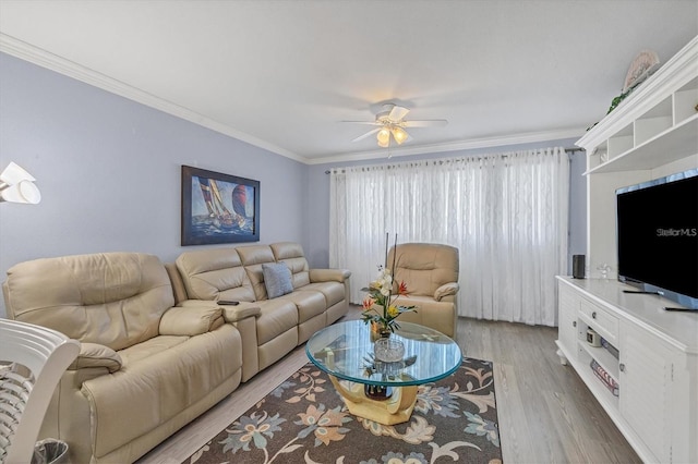 living room featuring hardwood / wood-style floors, ornamental molding, and ceiling fan