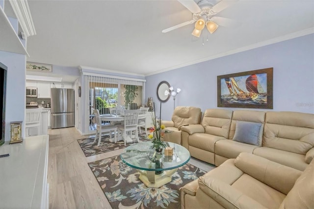 living room with ornamental molding, ceiling fan, and light hardwood / wood-style floors