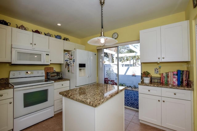 kitchen with white cabinets, a kitchen island, and white appliances