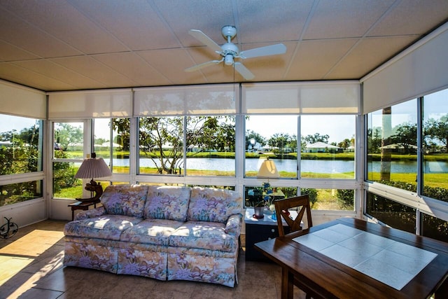 sunroom featuring a water view and ceiling fan