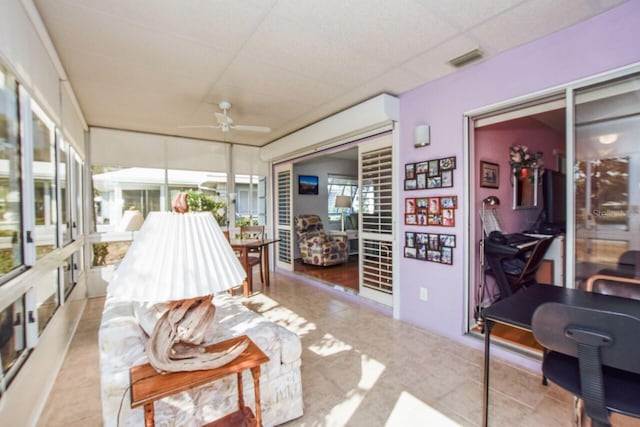 sunroom / solarium featuring a paneled ceiling and ceiling fan