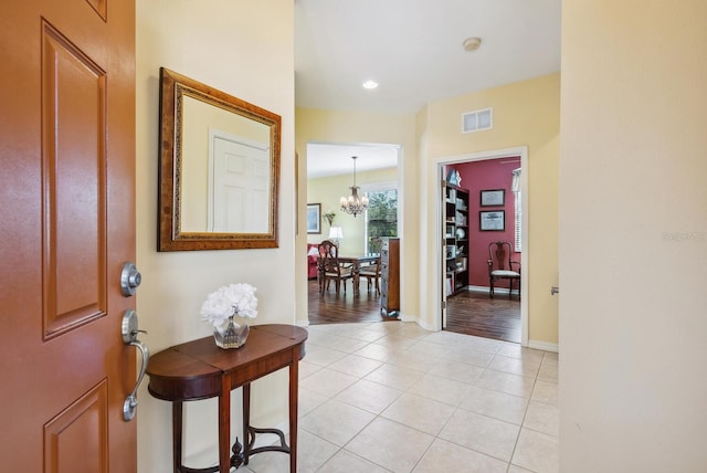 tiled entrance foyer featuring a notable chandelier