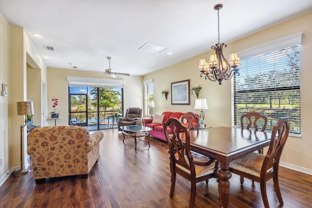 dining area featuring ceiling fan with notable chandelier and dark wood-type flooring