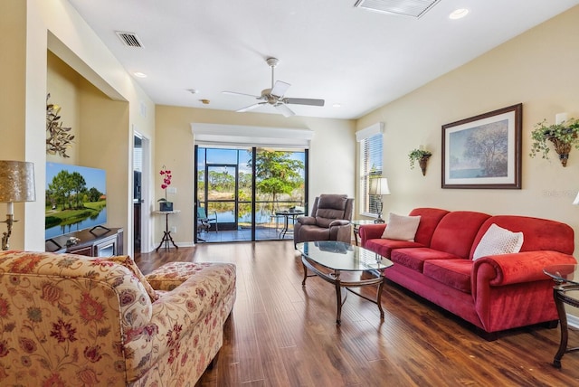 living room featuring ceiling fan and dark hardwood / wood-style floors