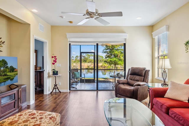 living room featuring dark wood-type flooring, a wealth of natural light, and ceiling fan