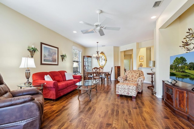 living room featuring ceiling fan with notable chandelier and dark hardwood / wood-style floors