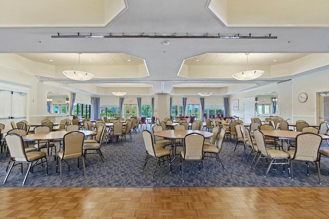 dining space with parquet floors and a raised ceiling