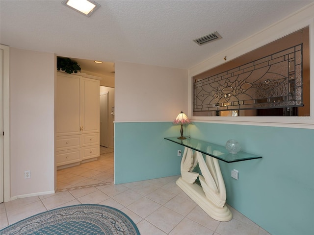 bathroom featuring a textured ceiling and tile patterned flooring