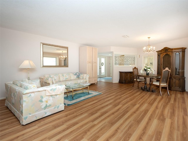 living room with a notable chandelier and light wood-type flooring