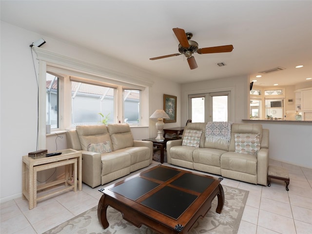 tiled living room featuring ceiling fan and french doors