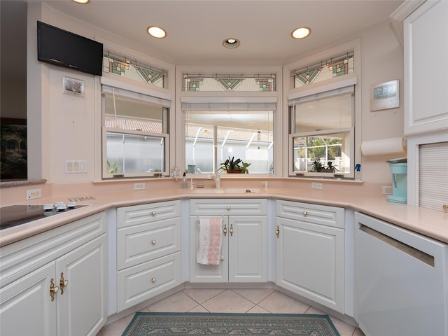 kitchen with light tile patterned floors, sink, white cabinets, and dishwasher