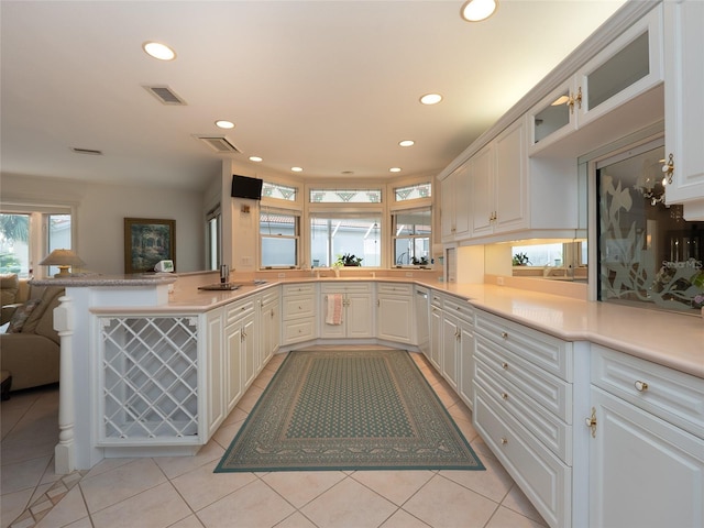 kitchen featuring white cabinets, light tile patterned floors, and kitchen peninsula