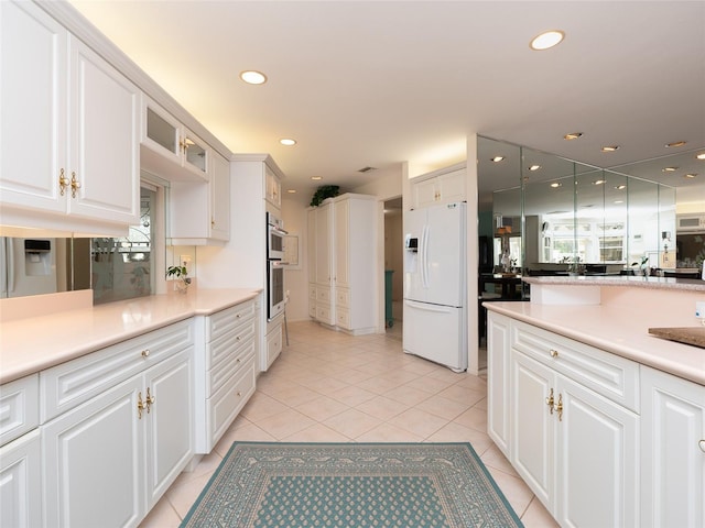 kitchen featuring light tile patterned floors, white cabinetry, and white refrigerator with ice dispenser