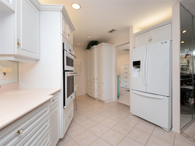 kitchen featuring white appliances, white cabinets, and light tile patterned flooring