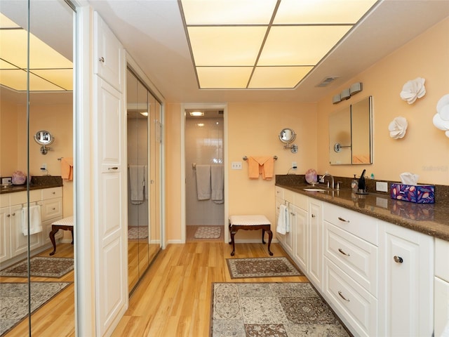 bathroom featuring vanity, hardwood / wood-style flooring, and a tile shower