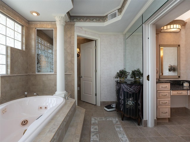 bathroom featuring decorative columns, vanity, tiled tub, and ornamental molding