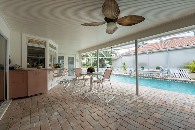 view of swimming pool with glass enclosure, a patio, and a bar