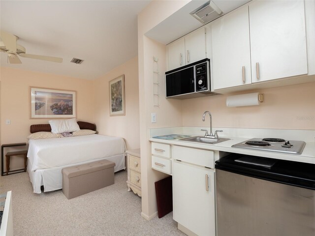 bedroom featuring sink, light colored carpet, and ceiling fan