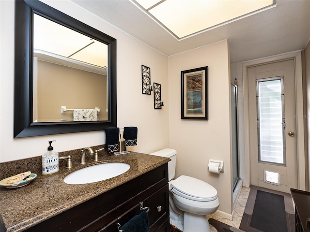 bathroom featuring vanity, toilet, a healthy amount of sunlight, and walk in shower