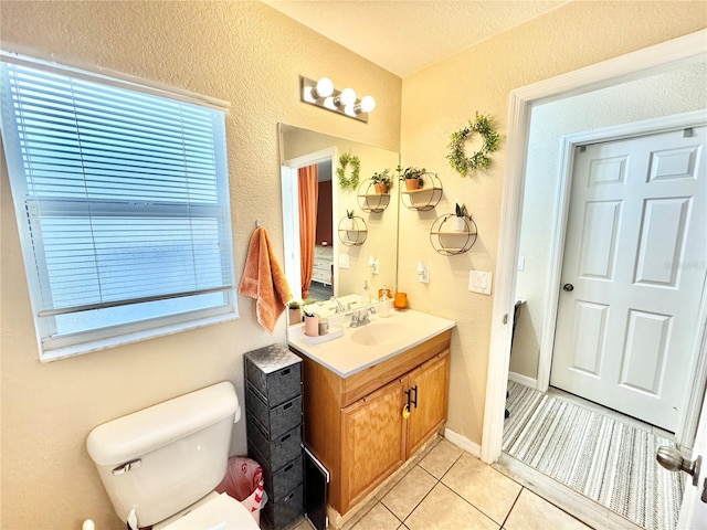 bathroom with toilet, tile patterned floors, and vanity