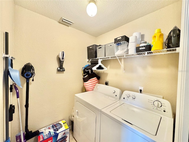 laundry room featuring a textured ceiling and washer and dryer