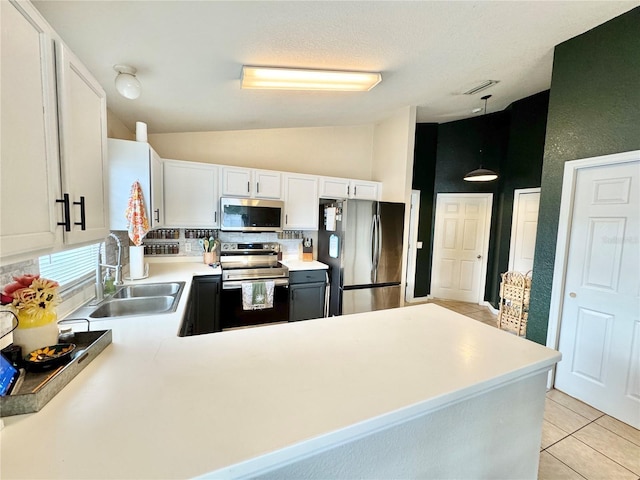 kitchen with pendant lighting, sink, light tile patterned flooring, white cabinetry, and stainless steel appliances