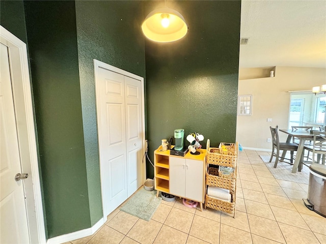 interior space with light tile patterned floors and lofted ceiling