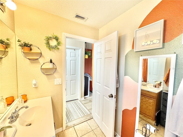 bathroom featuring a textured ceiling, vanity, and tile patterned flooring