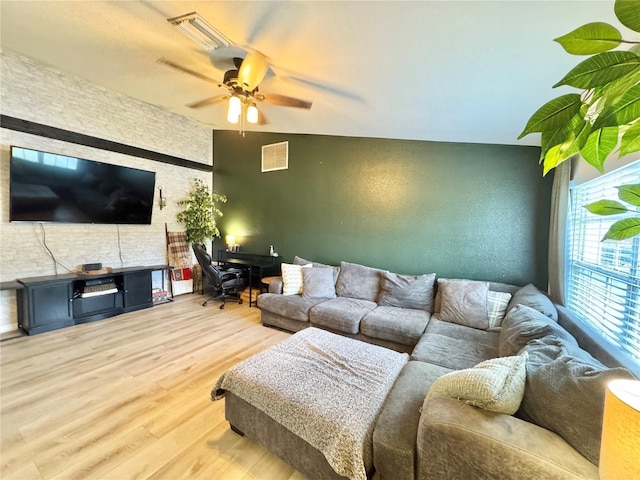 living room with ceiling fan, lofted ceiling, and hardwood / wood-style floors