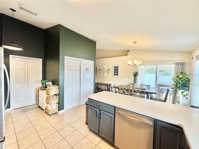 kitchen featuring lofted ceiling, stainless steel appliances, an inviting chandelier, hanging light fixtures, and light tile patterned flooring