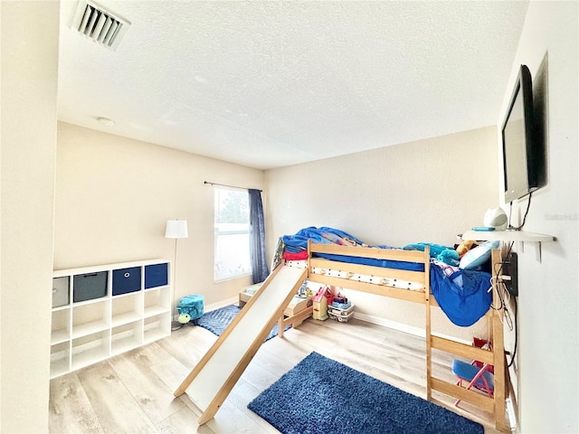 bedroom with hardwood / wood-style flooring and a textured ceiling