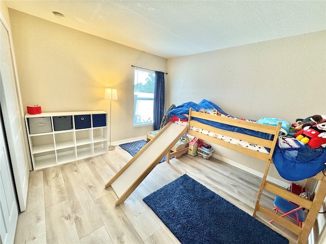 bedroom featuring hardwood / wood-style flooring and a textured ceiling