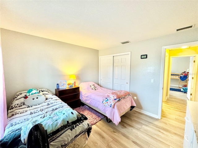 bedroom featuring light wood-type flooring and a closet