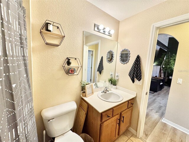 bathroom with hardwood / wood-style flooring, vanity, and toilet