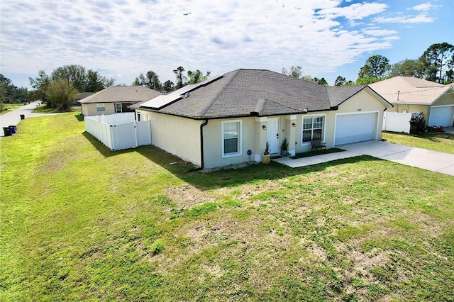 single story home featuring a garage, a front yard, and solar panels