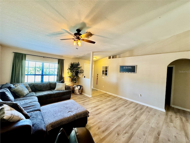 8307 Glover Ave, North Port, FL 34291 - living area with light wood-style floors, arched walkways, a textured ceiling, a ceiling fan, and vaulted ceiling
