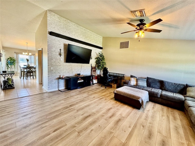 8307 Glover Ave, North Port, FL 34291 - living area with ceiling fan with notable chandelier, a textured ceiling, vaulted ceiling, visible vents, and wood finished floors