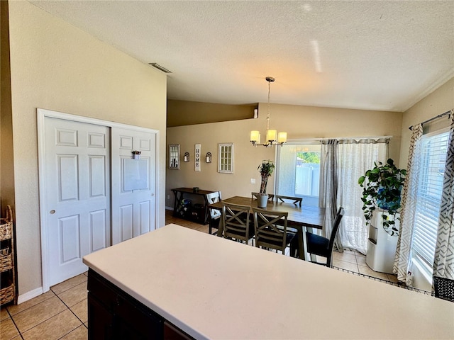 8307 Glover Ave, North Port, FL 34291 - dining area featuring light tile patterned floors, a textured ceiling, visible vents, a chandelier, and lofted ceiling