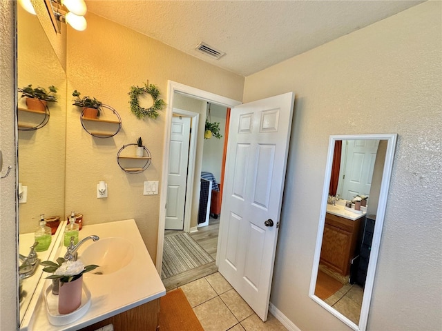 8307 Glover Ave, North Port, FL 34291 - bathroom featuring visible vents, a textured wall, a textured ceiling, vanity, and tile patterned flooring
