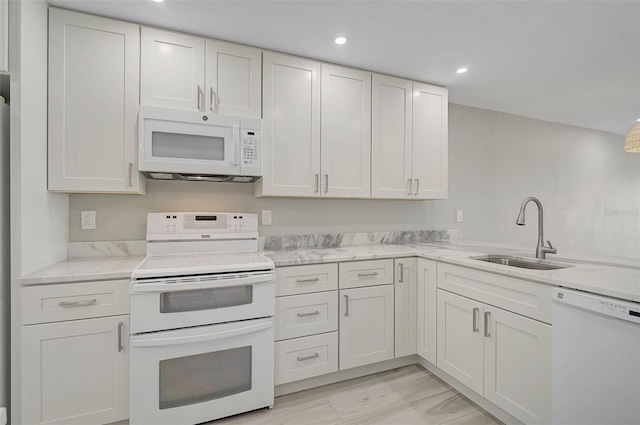 kitchen featuring light stone countertops, sink, white appliances, and white cabinetry