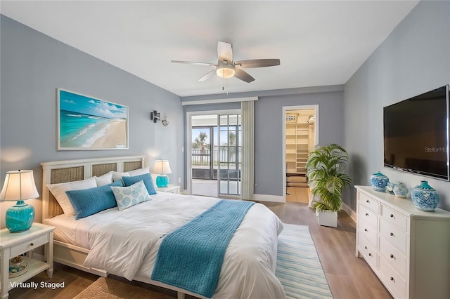 bedroom featuring ceiling fan, a spacious closet, light hardwood / wood-style flooring, and access to outside