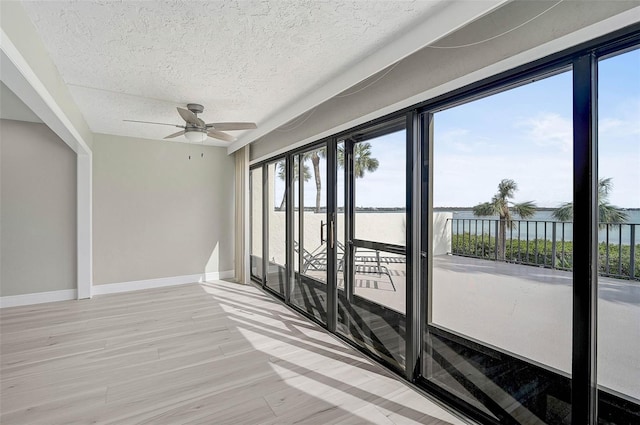 interior space featuring ceiling fan and a water view