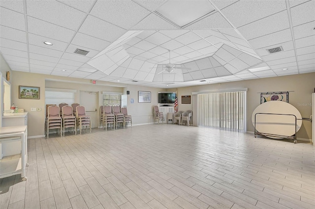 interior space with ceiling fan and a drop ceiling