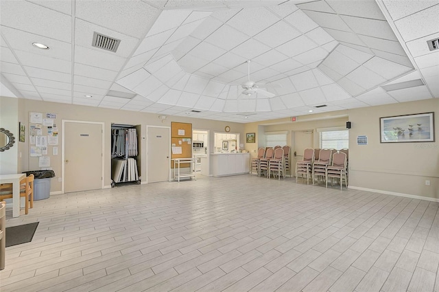 interior space with ceiling fan and a drop ceiling