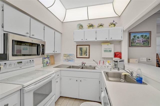 kitchen featuring electric stove, white cabinetry, and sink