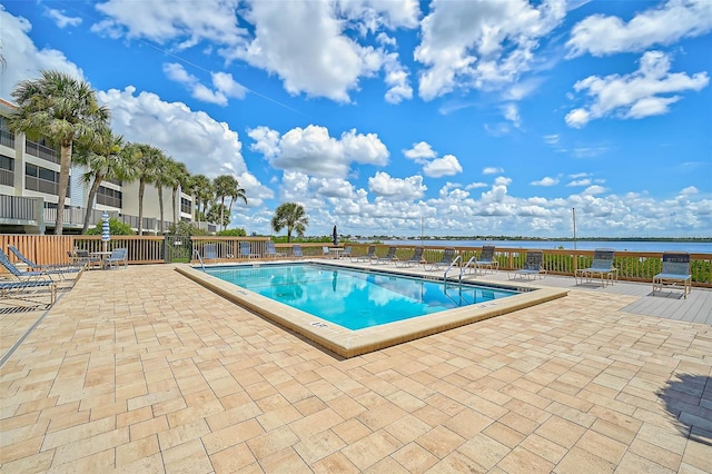 view of pool with a patio area and a water view