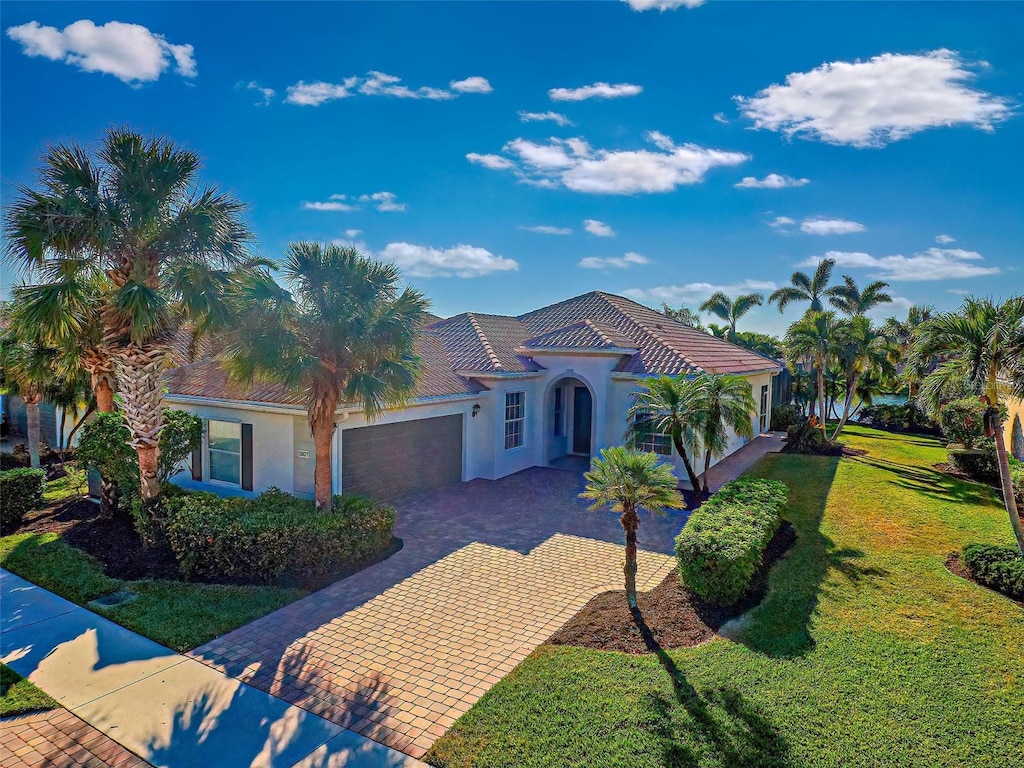 mediterranean / spanish-style home featuring a front lawn and a garage